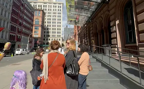 Group exploring New York City street during self-guided Basquiat-themed tour.