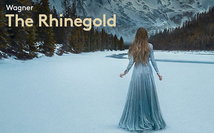 Person in a long dress walking on snow with mountains and trees in the background, related to The Rhinegold.