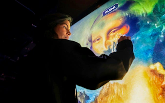 Interactive digital art display at Mercer Labs Museum of Art, featuring a visitor engaging with a touch screen.