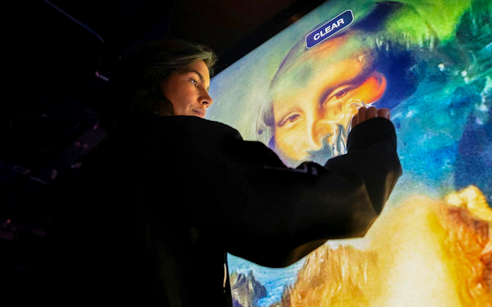 Interactive digital art display at Mercer Labs Museum of Art, featuring a visitor engaging with a touch screen.