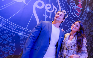 Visitors standing in front of La Perle banner in Dubai.