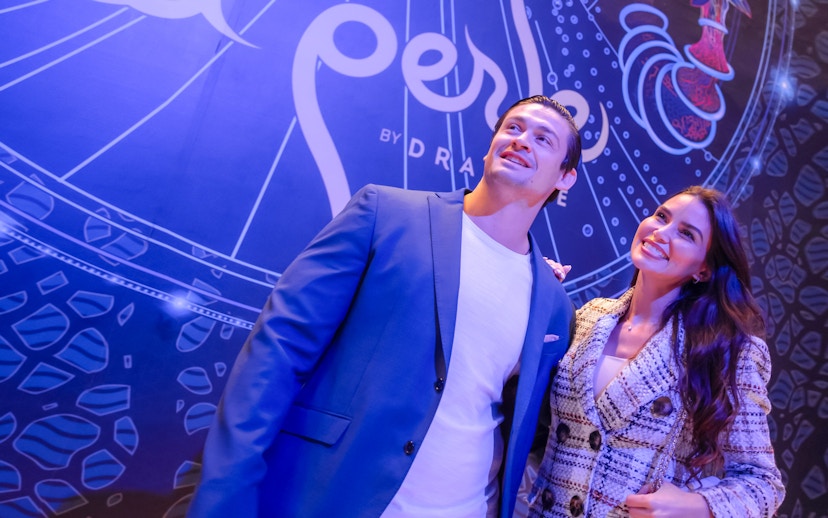 Visitors standing in front of La Perle banner in Dubai.