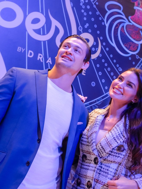 Visitors standing in front of La Perle banner in Dubai.