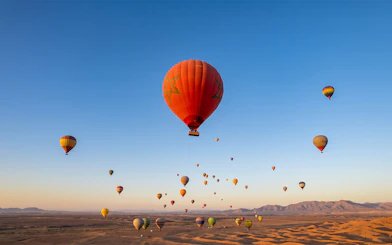 Hot air balloons over Marrakesh desert at sunrise.