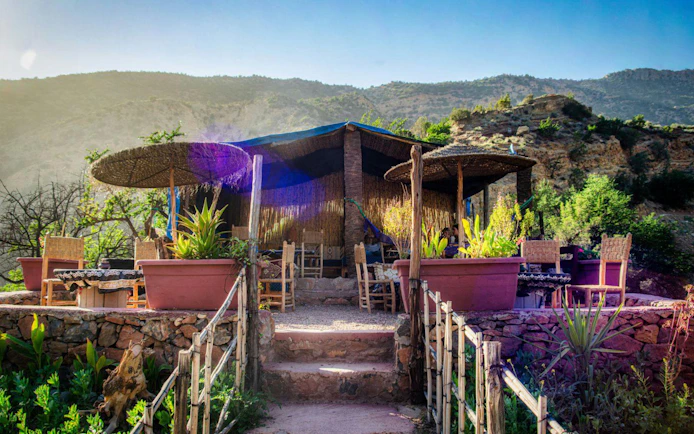 Outdoor seating area with rustic decor in Paradise Valley, surrounded by lush greenery and mountains.