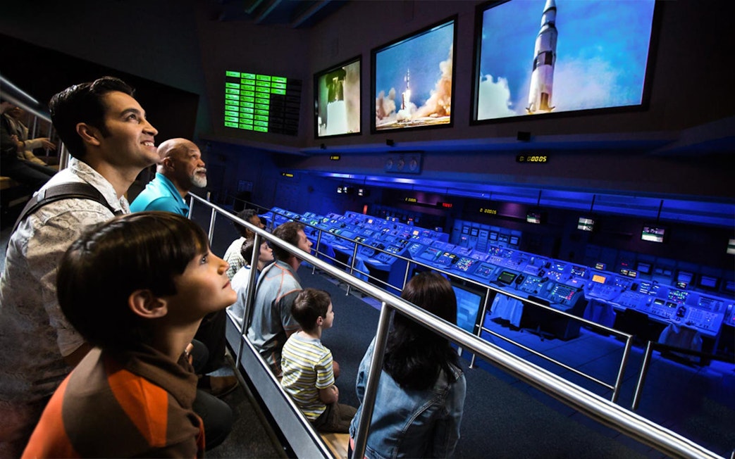 Visitors watching a rocket launch simulation at Apollo Saturn V Center Firing Room.