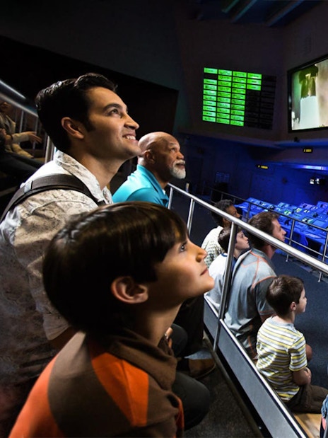 Visitors watching a rocket launch simulation at Apollo Saturn V Center Firing Room.