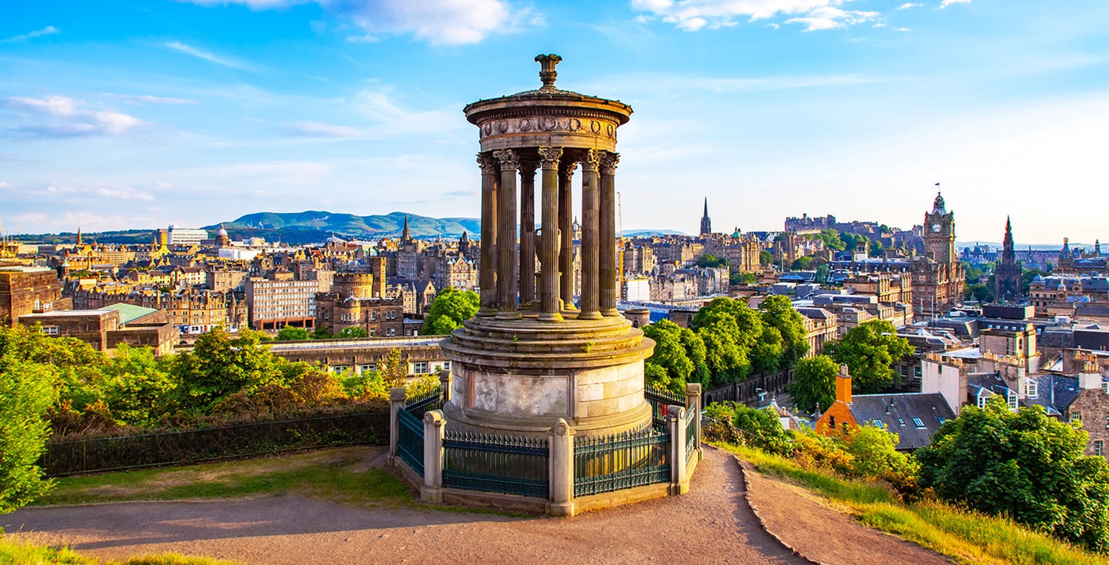 Dugald Stewart Monument on Calton Hill overlooking Edinburgh cityscape.
