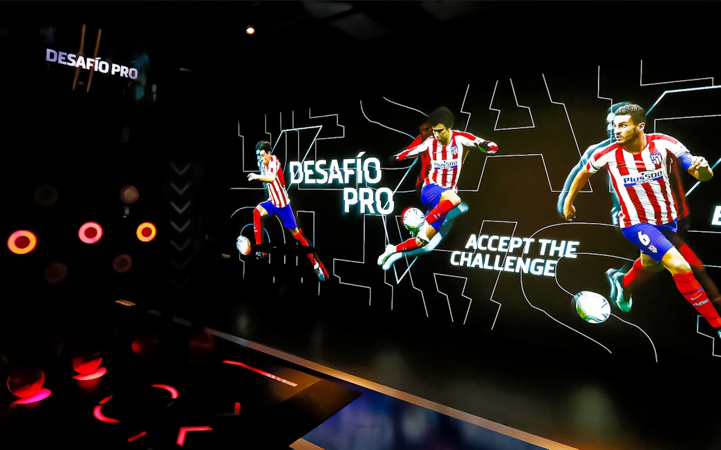 Interactive exhibit at Atletico de Madrid Stadium Tour featuring players in action.