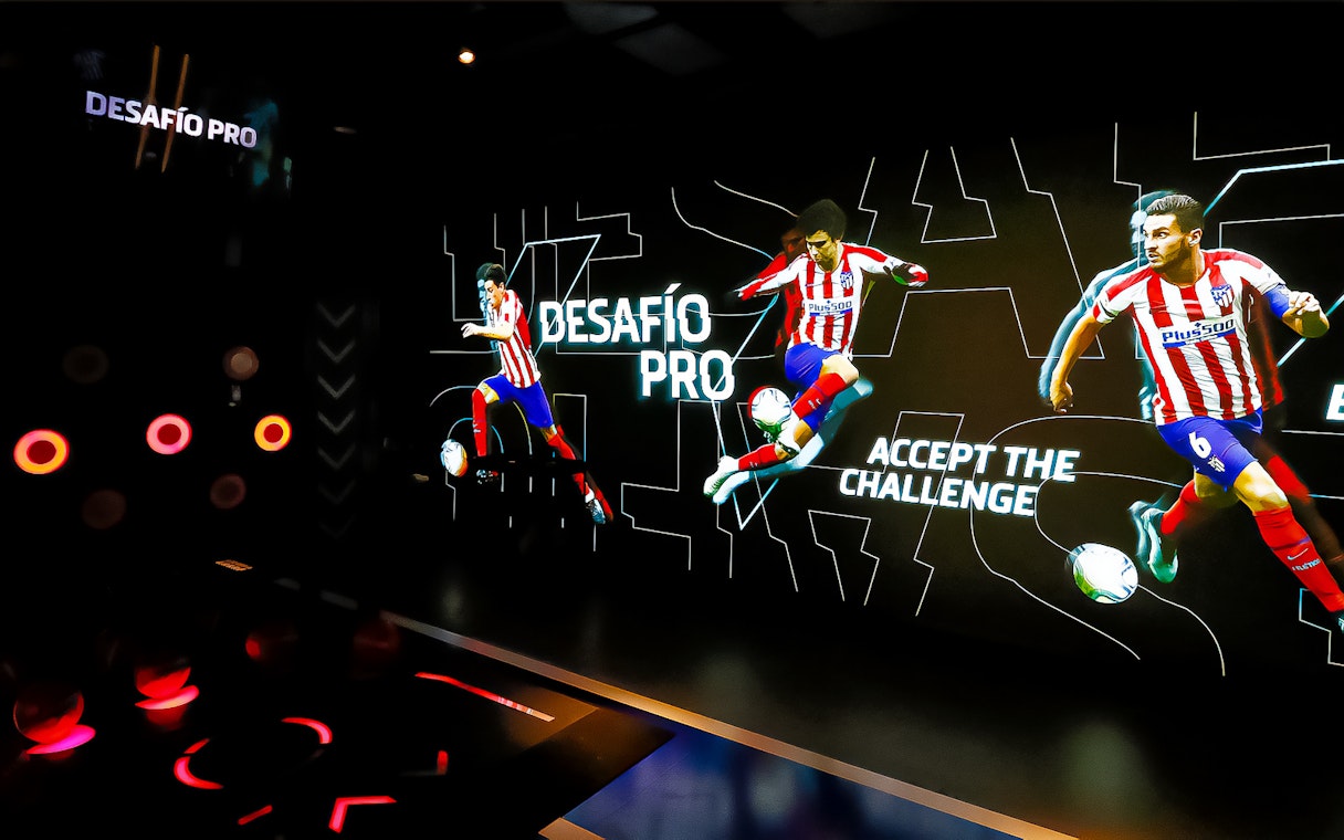 Interactive exhibit at Atletico de Madrid Stadium Tour featuring players in action.