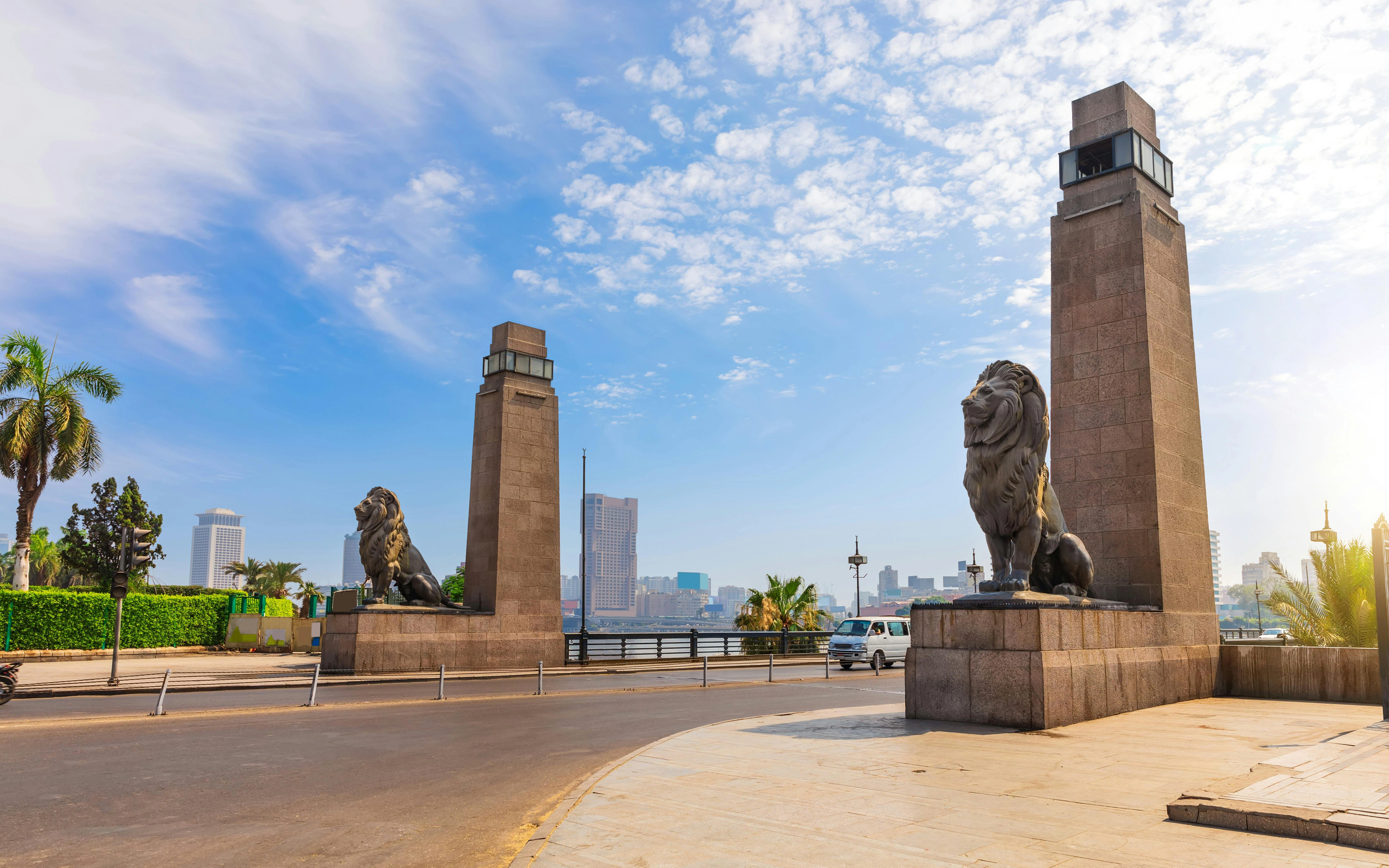 Qasr El Nil Bridge with lion statues and cityscape in Cairo, Egypt.
