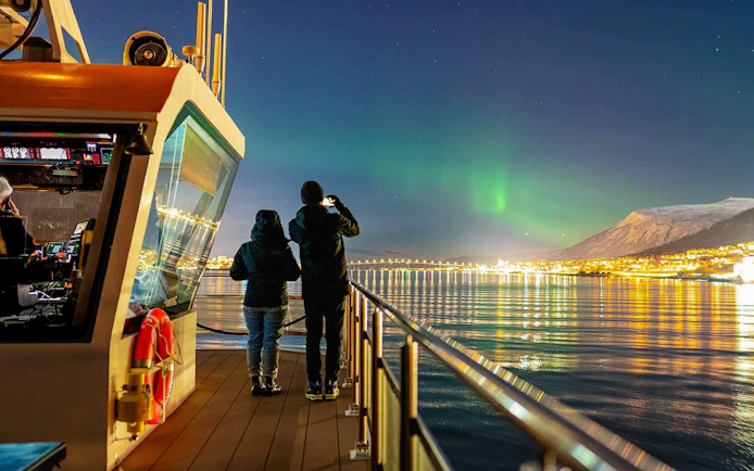 Northern lights over Tromso viewed from a cruise ship deck.