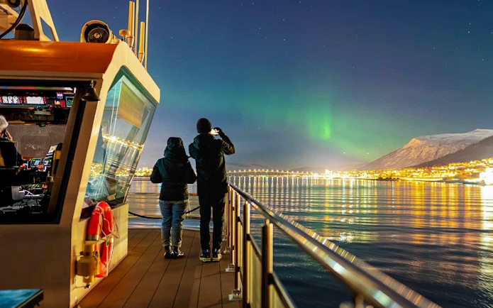 Northern lights over Tromso viewed from a cruise ship deck.