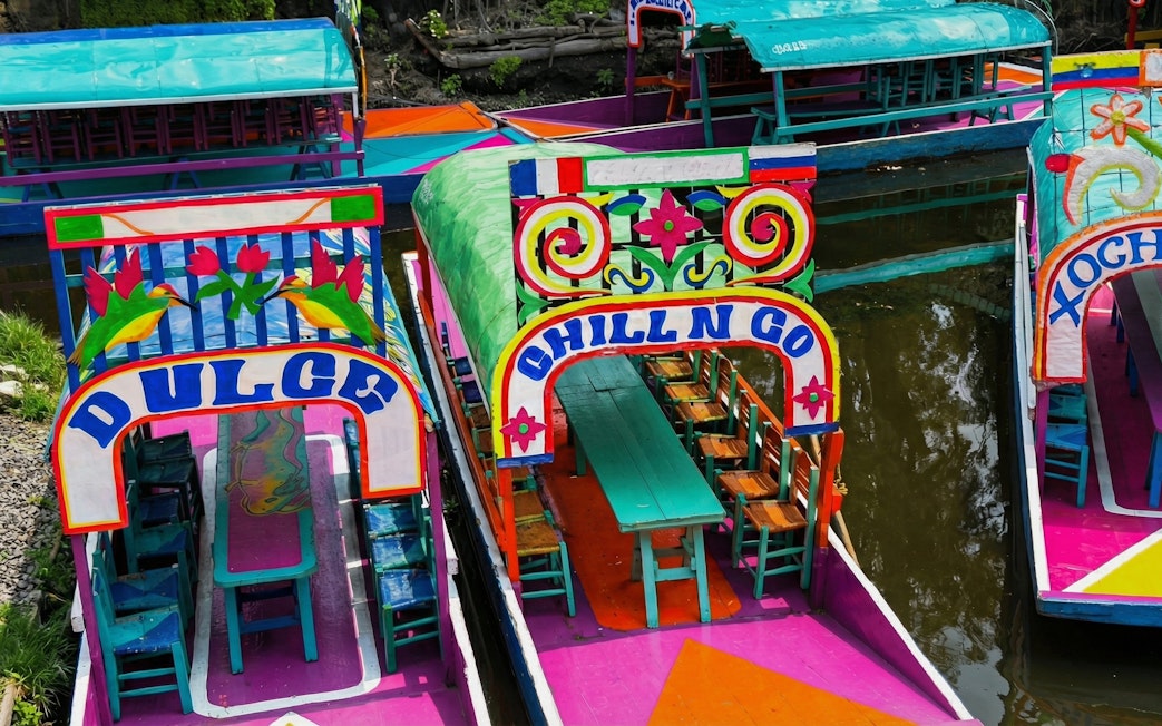 Colorful trajineras on Xochimilco canal for small group floating adventure.