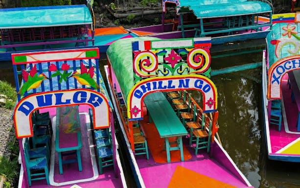 Colorful trajineras on Xochimilco canal for small group floating adventure.