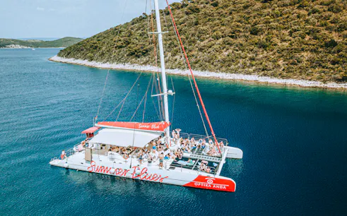 Catamaran with tourists cruising near Hvar and Pakleni Islands, Croatia.