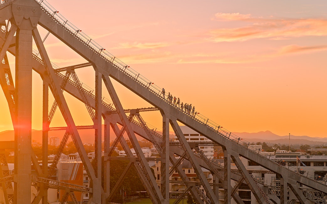 Climbers ascending Story Bridge at twilight in Brisbane.