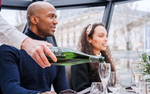 Pouring champagne on Bateaux Mouches Seine River cruise in Paris.