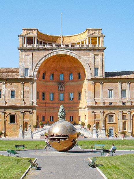 Tourists in Vatican Museums courtyard with Sphere Within Sphere sculpture, Rome, Italy.