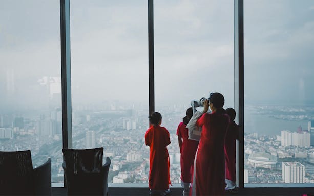 Visitors in red attire view Hanoi from Sky Lotte Observation Deck.
