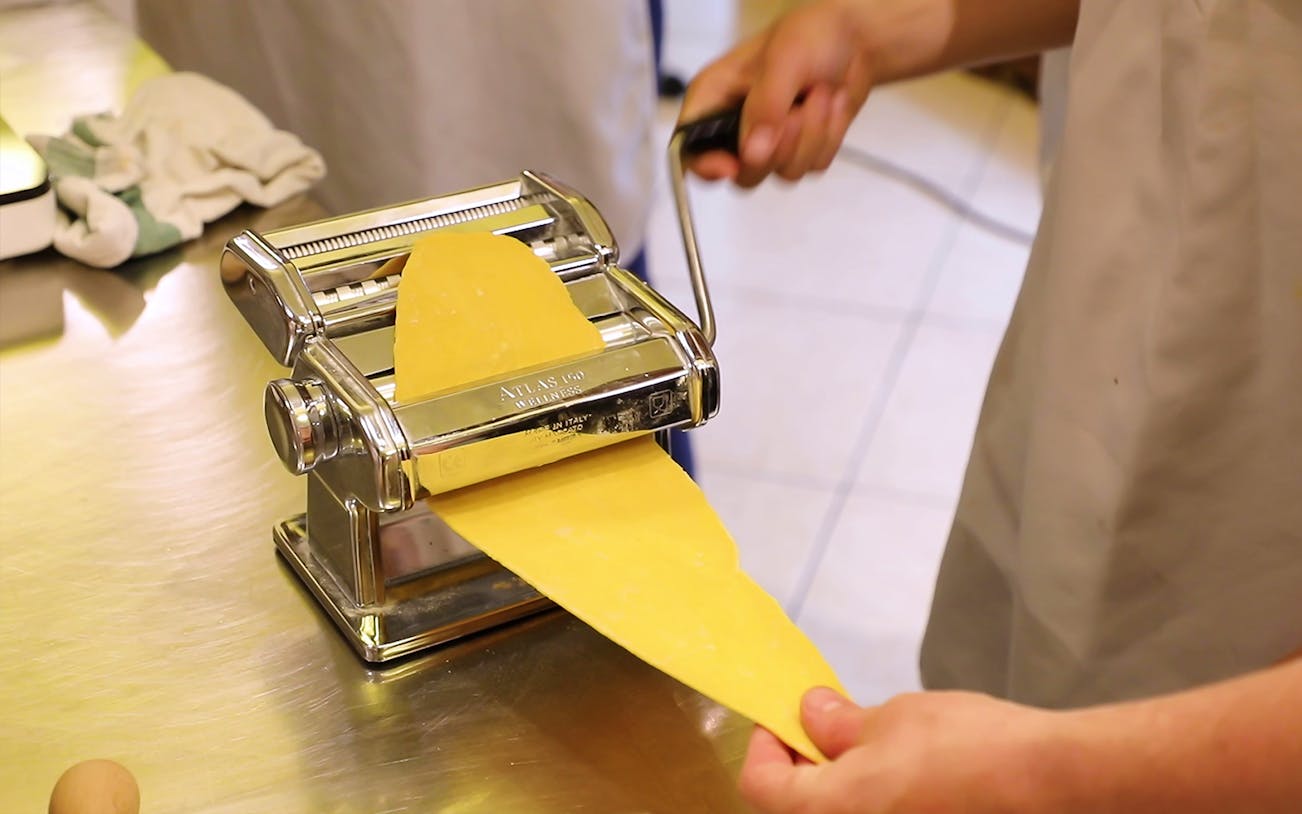 Making pasta with a machine during a cooking class in Florence.