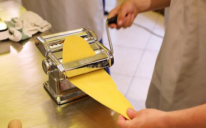 Making pasta with a machine during a cooking class in Florence.