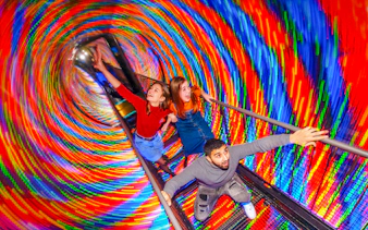 Visitors experiencing the colorful Vortex Tunnel at Camera Obscura & World of Illusions, Edinburgh.