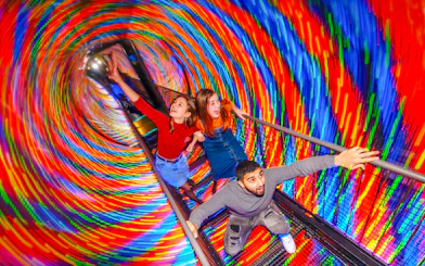 Visitors experiencing the colorful Vortex Tunnel at Camera Obscura & World of Illusions, Edinburgh.