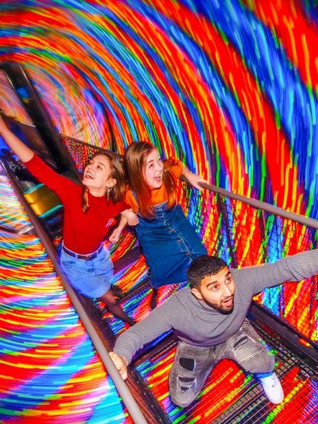 Visitors experiencing the colorful Vortex Tunnel at Camera Obscura & World of Illusions, Edinburgh.