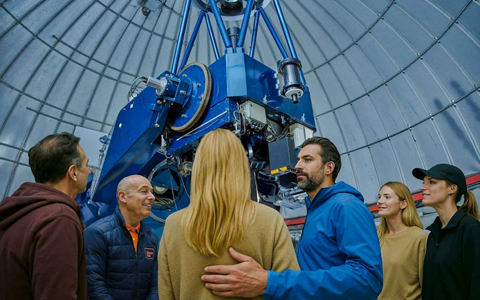 Guests observing telescope at Mount Teide observatory during astronomic tour.