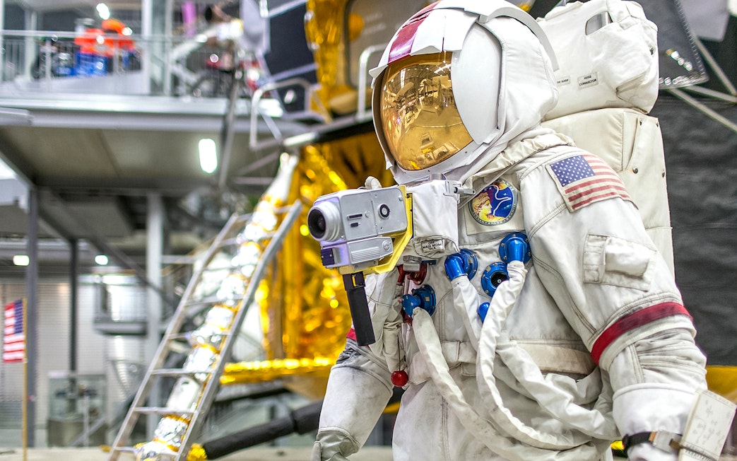 Astronaut suit display at Technik Museum Speyer with lunar module backdrop.