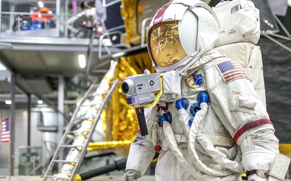 Astronaut suit display at Technik Museum Speyer with lunar module backdrop.