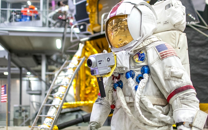 Astronaut suit display at Technik Museum Speyer with lunar module backdrop.