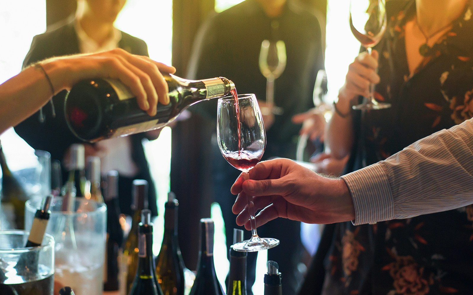 Wine being poured into a glass at a vineyard tour in Tuscany, Italy.