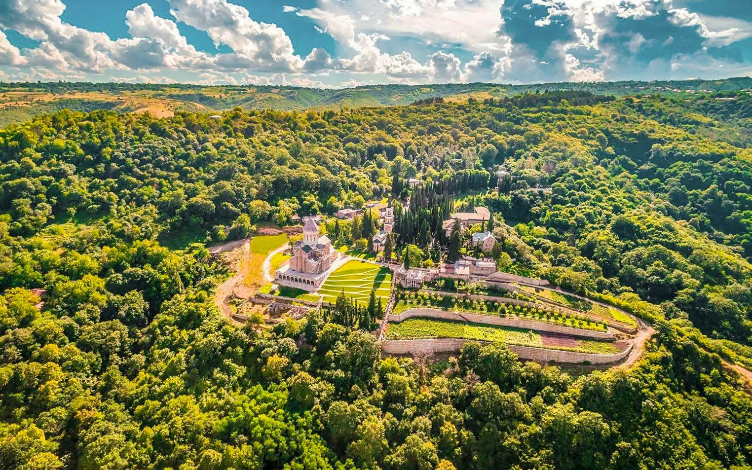 Aerial view of Bodbe Monastery surrounded by lush greenery near Sighnaghi, Kakheti.