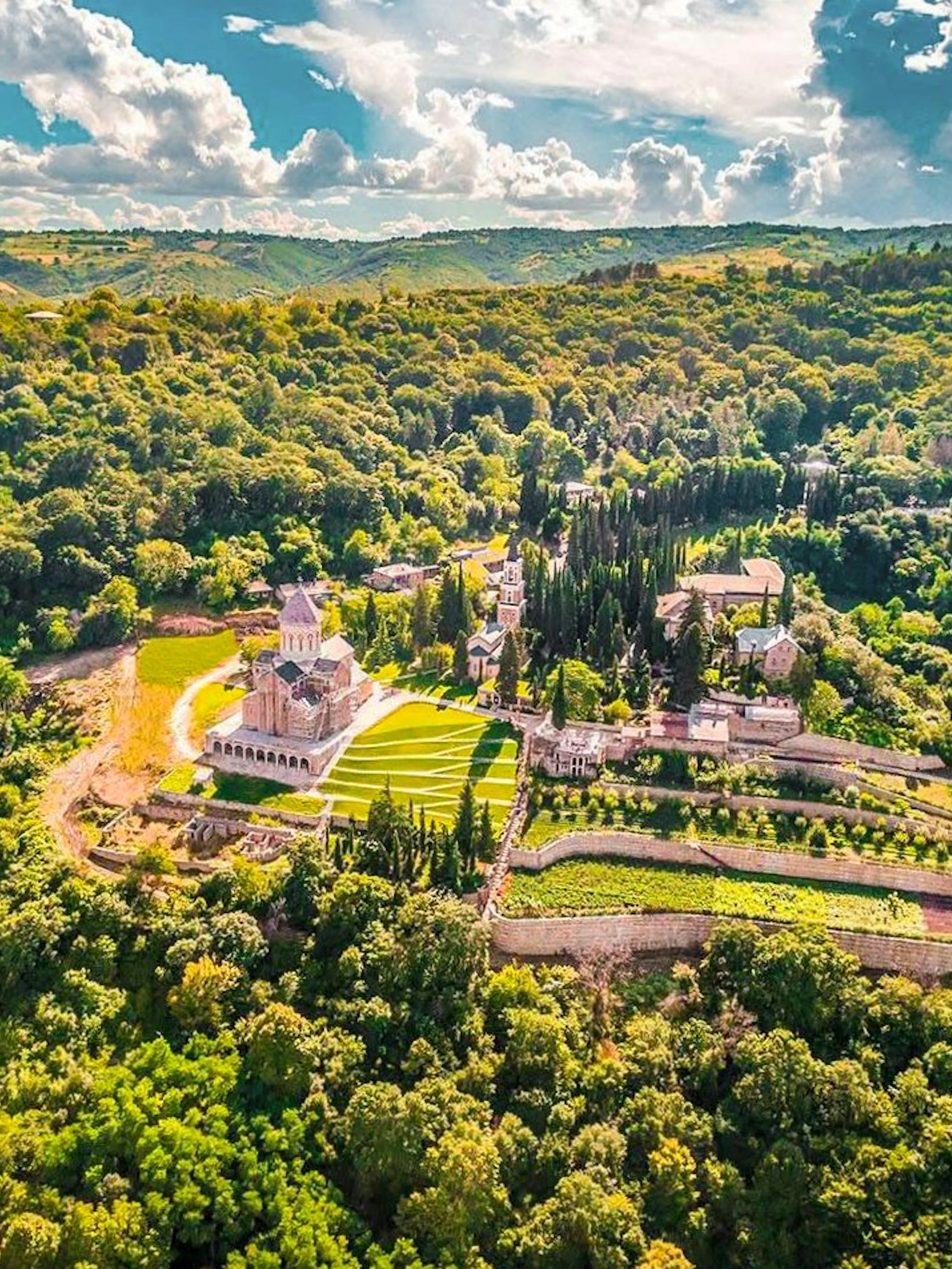 Aerial view of Bodbe Monastery surrounded by lush greenery near Sighnaghi, Kakheti.