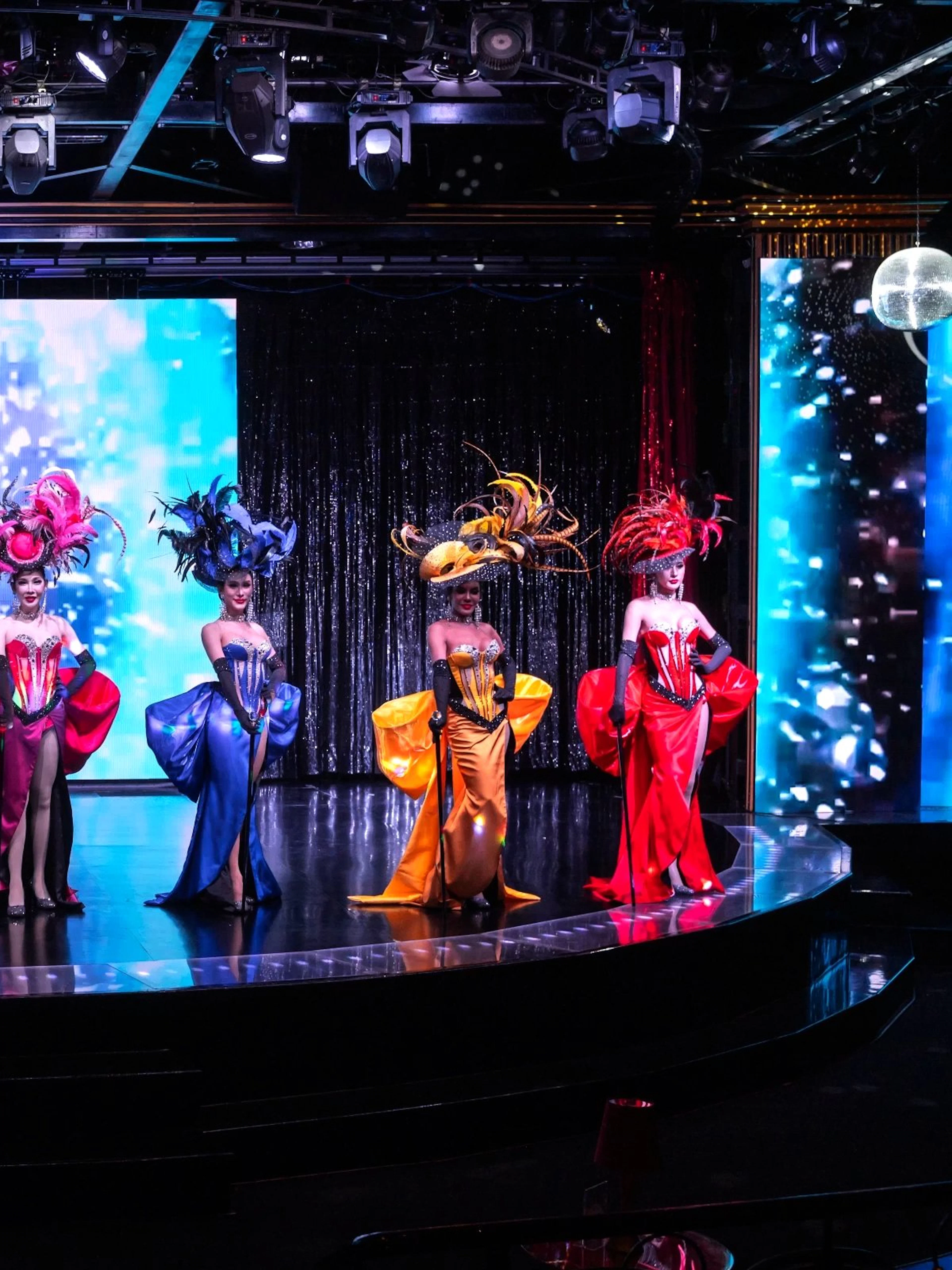 Performers in vibrant costumes on stage at Calypso Cabaret, Bangkok.