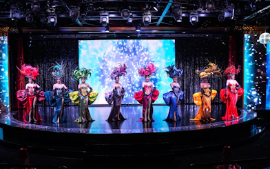 Performers in vibrant costumes on stage at Calypso Cabaret, Bangkok.
