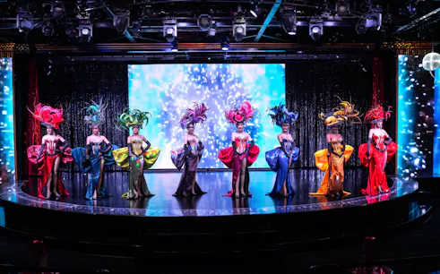 Performers in vibrant costumes on stage at Calypso Cabaret, Bangkok.
