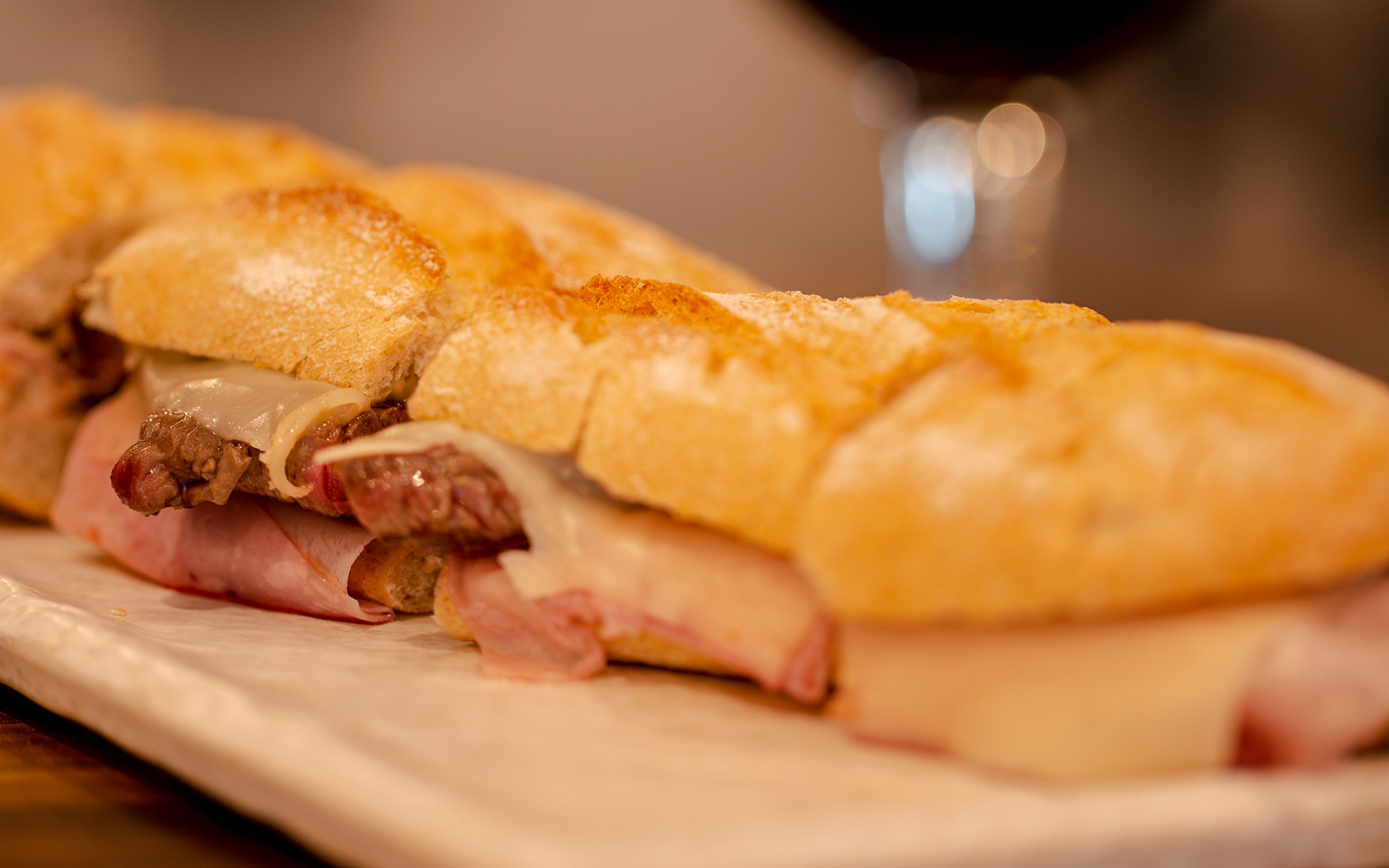 Prego no Pao sandwich with steak and cheese on a plate.