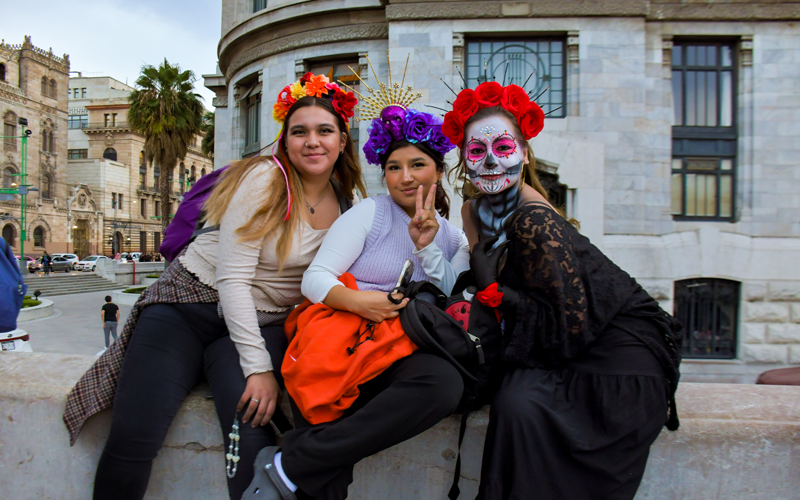 Tourists in traditional Day of the Dead attire at a parade in Mexico City.