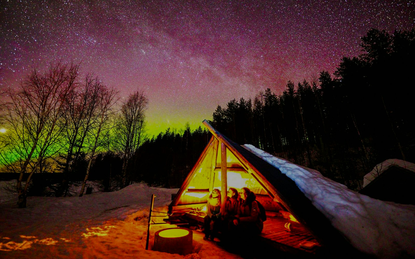 Chasing Northern Lights in Rovaniemi with traditional barbecue under starry sky.