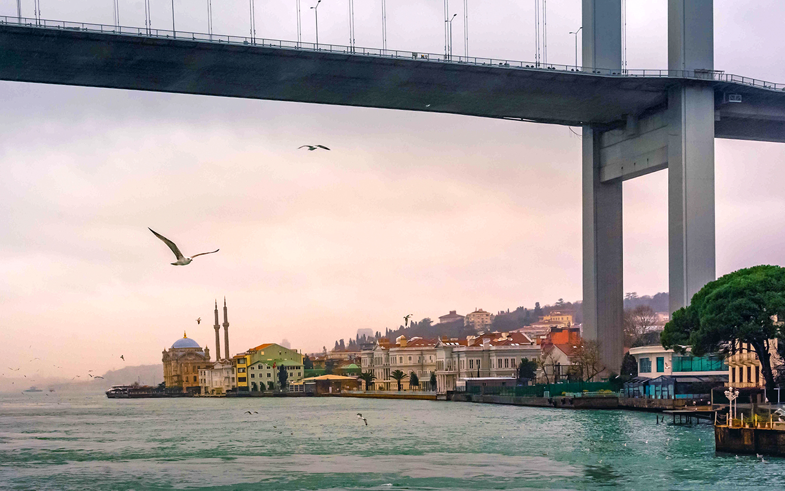 Bosphorus bridge and mosque at sunset during Golden Horn Cruise in Istanbul.