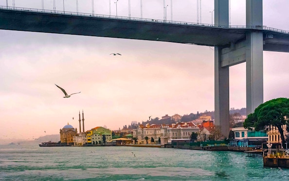Bosphorus bridge and mosque at sunset during Golden Horn Cruise in Istanbul.