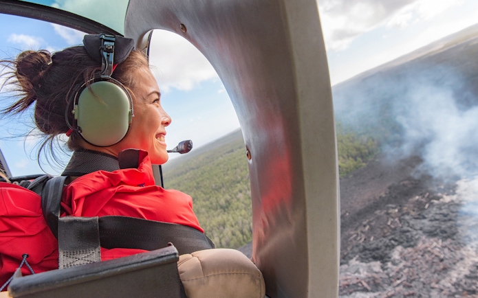 Young tourist in helicopter viewing Mount Etna landscape.