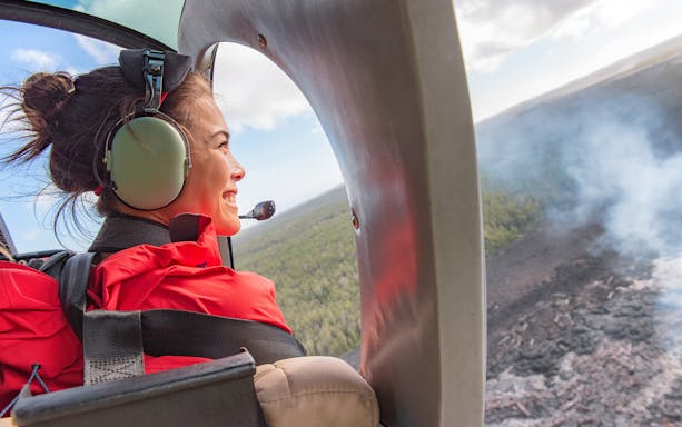 Young tourist in helicopter viewing Mount Etna landscape.