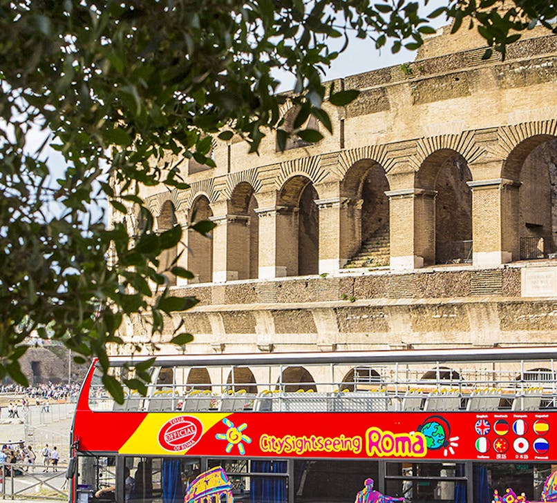 Open-top double-decker bus touring historic landmarks in Rome, Italy.