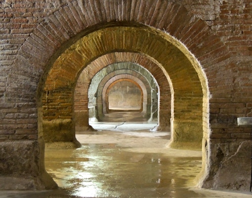 Naples underground tunnel with ancient stone arches on a guided tour in a Spanish neighborhood.