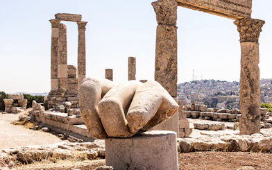 Temple of Hercules ruins with giant hand sculpture at Amman Citadel, Jordan.