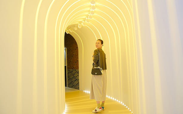Visitor exploring illuminated tunnel at Space & Time Cube in Bangkok.